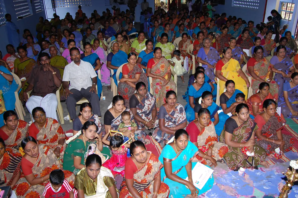 Large assembly of women self-help group members at a community awareness programme