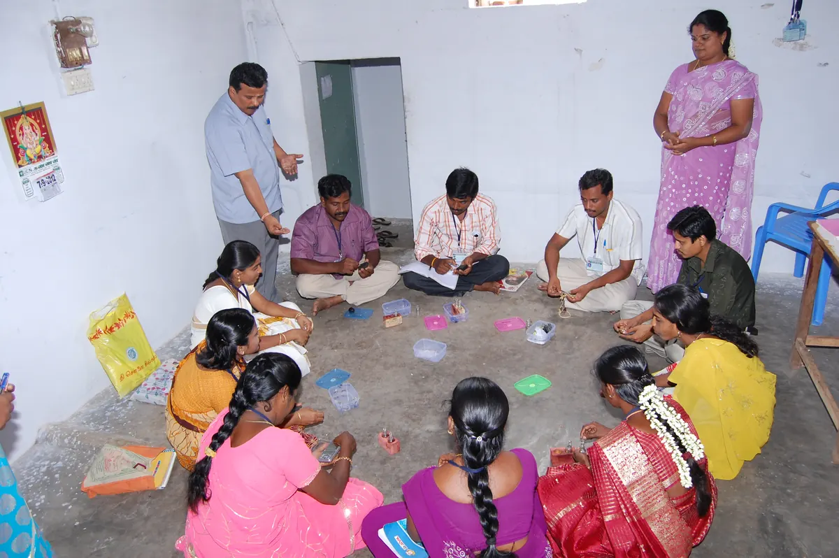Participants seated in circle practicing gold appraisal and jewellery valuation skills